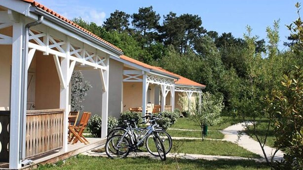 A covered outdoor seating area with a bicycle parked in front. - Apartment in Soulac-sur-mer Near Beach (Soulac-sur-Mer)