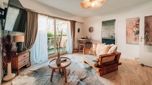 Ein modernes Wohnzimmer mit Sofa, Couchtisch, Fernseher und Essbereich.