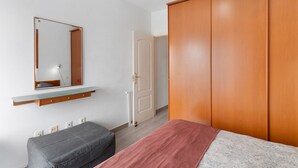 A bedroom with a bed, a wardrobe, a mirror, and a bedside table. - Vacation Apartment 'Vista Golf' with Sea View, Shared Pool and Wi-Fi (Mogán)