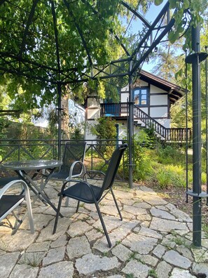 A patio area with stone flooring, metal chairs, and a glass table. - Come on in, relax, and make yourself comfortable. Idyllic location, close to downtown (Schwerin)
