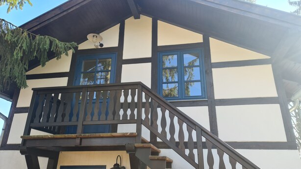 Ein traditionelles Fachwerkhäuschen mit Balkon und Treppe.