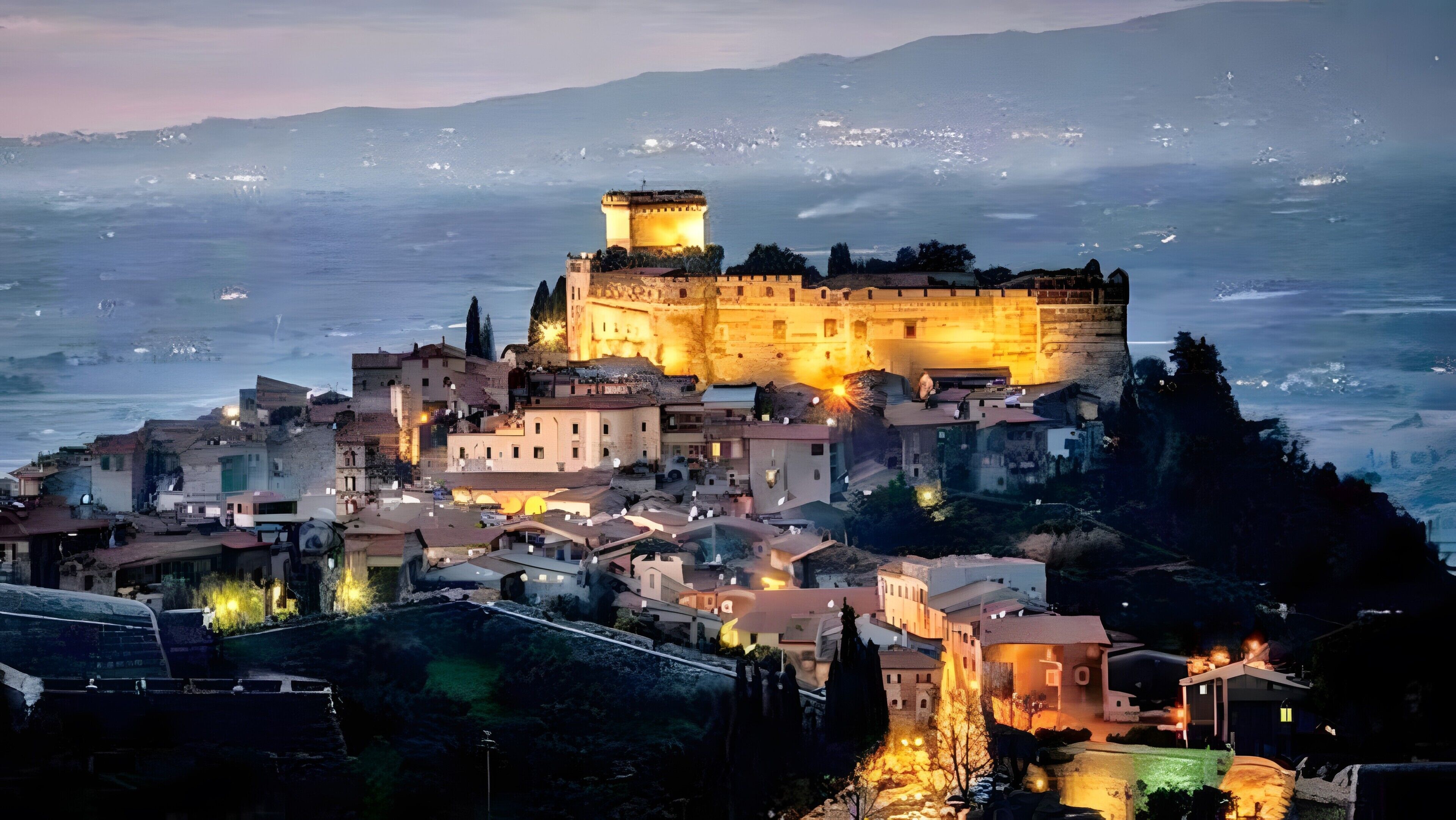A coastal town with a prominent castle-like structure, surrounded by residential buildings and a view of the sea.
