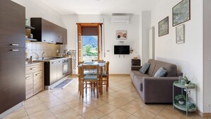 Een moderne keuken met een zithoek, een bank en een tv aan de muur.