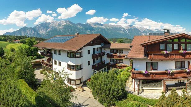 Un grand bâtiment à deux étages, doté de nombreux balcons, d’un café et d’un drapeau indiquant la présence d’une station de ski.