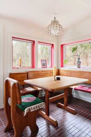 A room with a wooden bench, a table, and a hanging light fixture.