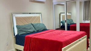 Een slaapkamer met een bed, een spiegel en een airconditioning.