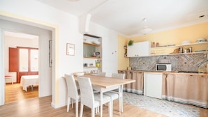 Una cucina moderna con un tavolo e sedie di legno, un forno a microonde e un lavandino.