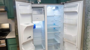An open refrigerator with multiple shelves and a water dispenser. - Renovated 1st Floor Beach 250ft Pool (South Padre Island)