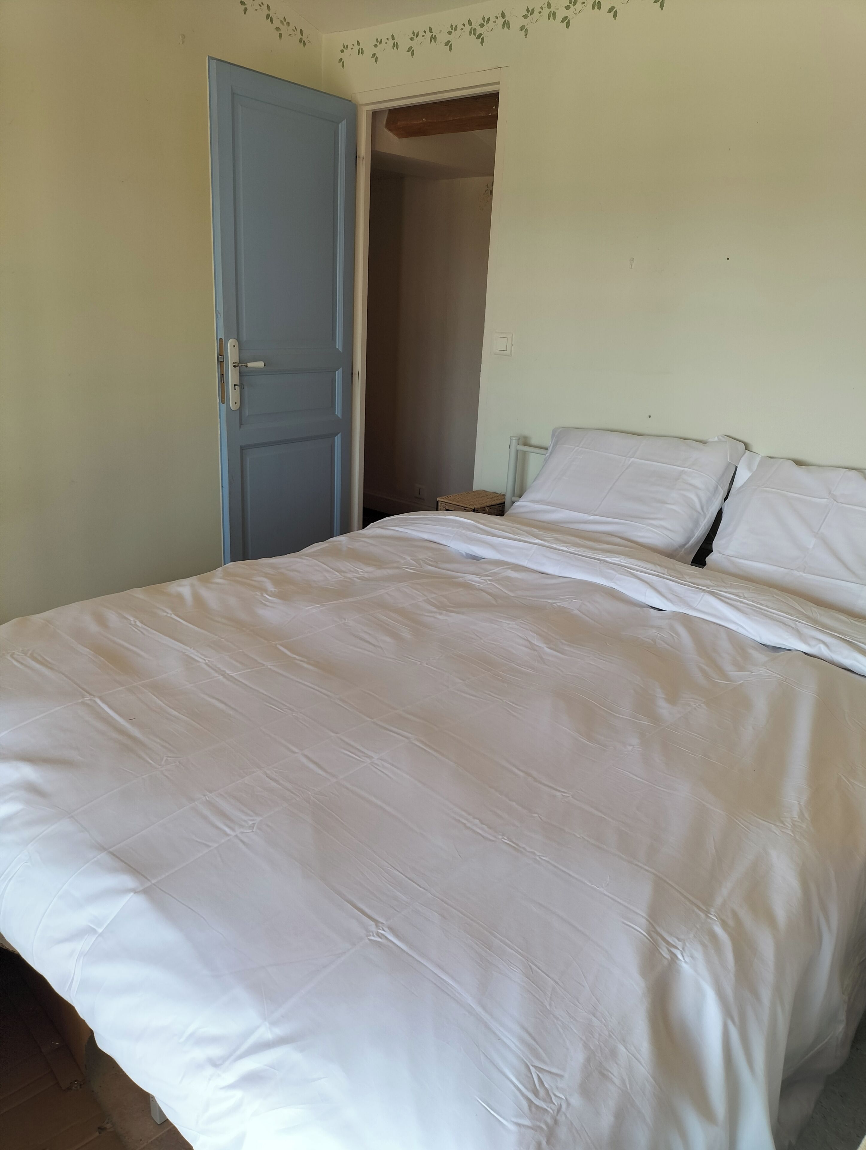 Une chambre à coucher avec un lit, une porte et une petite table.