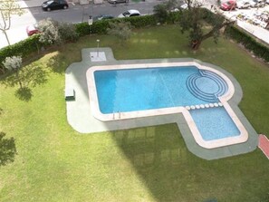 A rectangular pool with a unique design, surrounded by a well-maintained lawn and a hedge. - Islandia 15C in Benidorm (Benidorm)