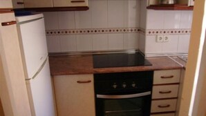 A compact kitchen with white cabinets, a black oven, and a countertop. - LAS Tejas 2-31 in Benidorm (Benidorm)