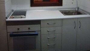 A compact kitchen with white cabinets, a built-in oven, a sink, and a window above the countertop. - Gemelos 4 4B2 in Benidorm (Benidorm)