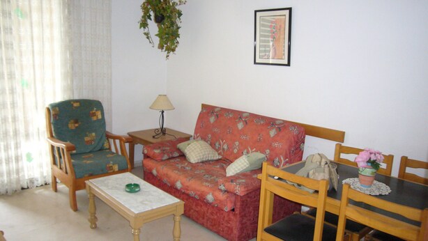 A living room with a sofa, armchair, coffee table, and a dining table with chairs. - Gemelos 4 4B2 in Benidorm (Benidorm)