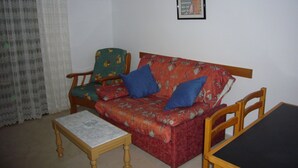 A living room with a red sofa, two blue pillows, a wooden coffee table, and a framed picture on the wall. - Gemelos 4 4B2 in Benidorm (Benidorm)