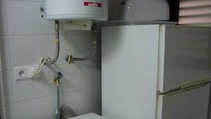 A compact laundry room with a washing machine, a small cabinet, and a water heater. - Gemelos 4 4B2 in Benidorm (Benidorm)