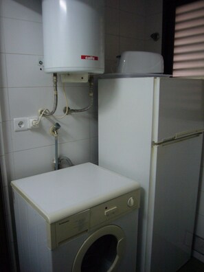 A compact laundry room with a washing machine, a small cabinet, and a water heater. - Gemelos 4 4B2 in Benidorm (Benidorm)