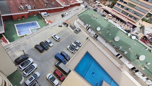 An aerial view of a parking lot with multiple cars, a swimming pool, and a tennis court. - Caballos 14H in Benidorm (Benidorm)