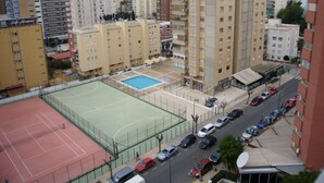 Un quartier résidentiel comprenant plusieurs immeubles de grande hauteur, un court de tennis et un parking.
