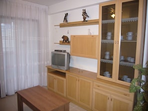 A living room with a wooden cabinet, a television, and a glass cabinet with cups. - Gemelos 12 10c1 in Benidorm (Benidorm)