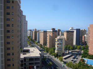 Ein Hochhaus mit mehreren Etagen, einem Parkplatz und freiem Blick auf das Meer im Hintergrund.
