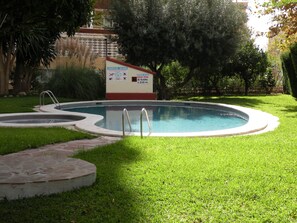 A swimming pool with a sign indicating the building name and operating hours. - Gijon 9B in Benidorm (Benidorm)