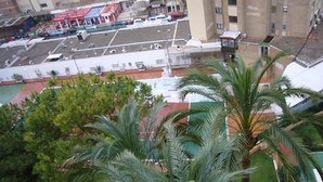 Un edificio alto con piscina sul tetto e un'area parcheggio.