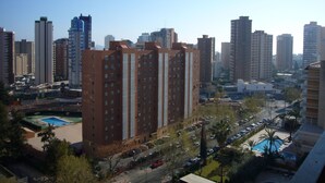 A high-rise building with multiple floors, surrounded by other tall buildings, a parking lot, and a swimming pool. - Finlandia 10D in Benidorm (Benidorm)