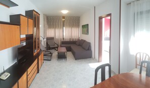 A living room with a sofa, chairs, a TV, and a dining table. - Gemelos 12 2D1 in Benidorm (Benidorm)