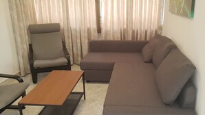 Ein Wohnzimmer mit einer Couch, einem Sessel und einem Couchtisch.