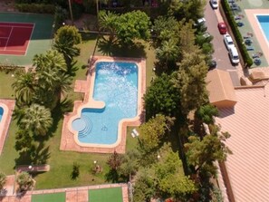 An aerial view of a residential area with a swimming pool, tennis courts, and parked cars. - Gemelos 12 2D1 in Benidorm (Benidorm)