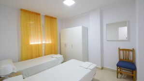 A room with two single beds, a wardrobe, a chair, and a mirror on the wall. - Oce3 3A in Benidorm With 2 Bedrooms and 1 Bathrooms (Benidorm)
