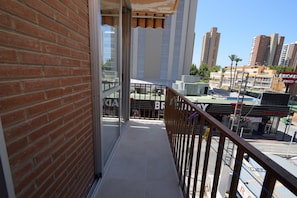 A balcony with a view of a commercial area, including a store with a 'DISCO-PUR' sign. - Oce3 3A in Benidorm With 2 Bedrooms and 1 Bathrooms (Benidorm)
