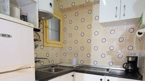 A compact kitchen with white cabinets, a black countertop, and a patterned backsplash. - Karola 8D in Benidorm (Benidorm)