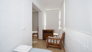 A small, bright room with a bed, a wooden chair, a wooden cabinet, and a radiator. - Karola 9A in Benidorm (Benidorm)