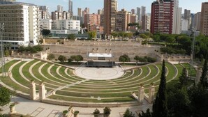 Una amplia plaza abierta con un espacio circular central, rodeada de edificios y vegetación.