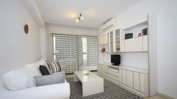 A modern living room with a white sofa, a coffee table, and a bookshelf. - Gemelos 4 3C1 in Benidorm (Benidorm)