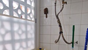 A compact laundry area with a washing machine, a sink, and a water heater. - Rinconada Real 159 in Benidorm (Benidorm)