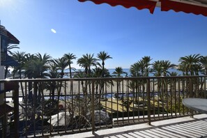 A balcony with a view of a beach, palm trees, and a clear sky. - SAN Pedro 3 Bedrooms (Benidorm)