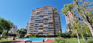 A high-rise apartment building with multiple balconies, a swimming pool, and surrounding greenery. - Lidersol 11f2 in Benidorm (Benidorm)