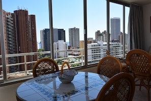 A balcony with a table and chairs, overlooking a cityscape with tall buildings. - Lidersol 11f2 in Benidorm (Benidorm)