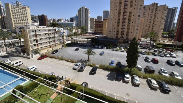 A parking lot with multiple cars, a hotel building, and high-rise residential buildings in the background. - Mariscal 4 4C in Benidorm (Benidorm)