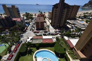 Ein Hochhaus-Hotel mit Pool, Blick auf den Strand und Parkplatz.