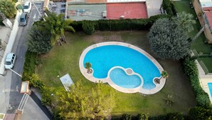 An aerial view of a residential area with a swimming pool, a red-roofed building, and a street with parked cars. - Castelmar 8B in Benidorm (Benidorm)