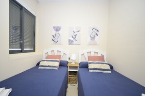 A twin room with two beds, a window with blinds, and three wall art pieces. - Gemelos 23 6C in Benidorm (Benidorm)