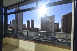 Ein Balkon mit Blick auf hohe Gebäude und einen klaren Himmel.