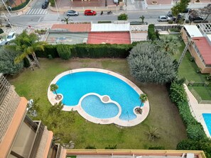 A residential area with a swimming pool, a road with vehicles, and surrounding greenery. - Castelmar 1C in Benidorm (Benidorm)