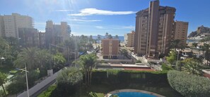 A residential area with high-rise buildings, a swimming pool, and palm trees. - Castelmar 1C in Benidorm (Benidorm)