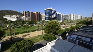 Un quartier résidentiel avec des immeubles d’appartements modernes, un parc planté de palmiers et un stade.