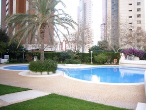 A swimming pool surrounded by greenery and tall buildings. - Parque Europa 5B1 in Benidorm (Benidorm)
