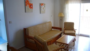 A living room with a sofa, two armchairs, a coffee table, and two paintings on the wall. - Oce3 2A in Benidorm With 2 Bedrooms and 1 Bathrooms (Benidorm)